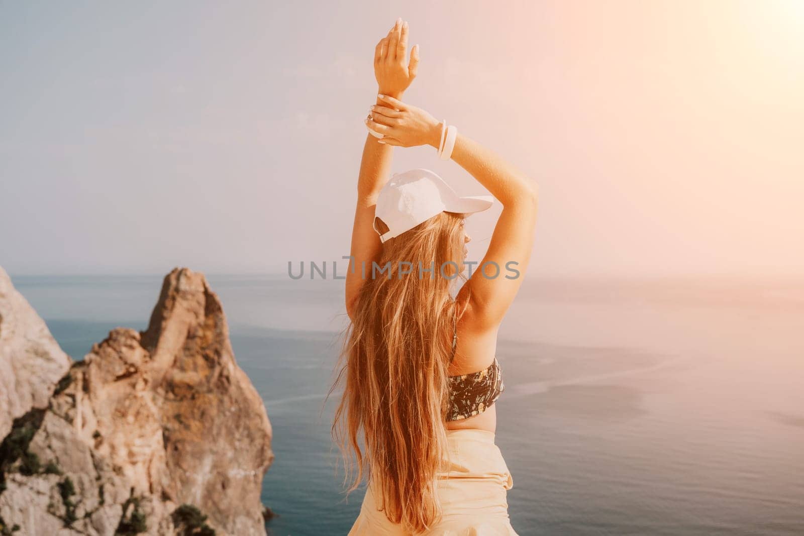 Woman travel sea. Happy tourist enjoy taking picture outdoors for memories. Woman traveler looks at the edge of the cliff on the sea bay of mountains, sharing travel adventure journey by panophotograph