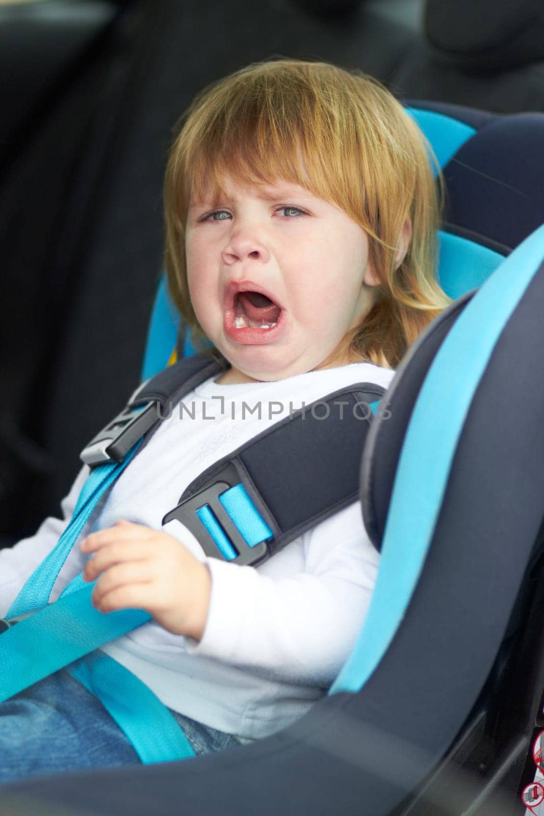Sad, crying and portrait of baby in car seat for fear, uncomfortable and travel safety. Security, transportation and journey with upset toddler for vacation trip, frustrated and protection.