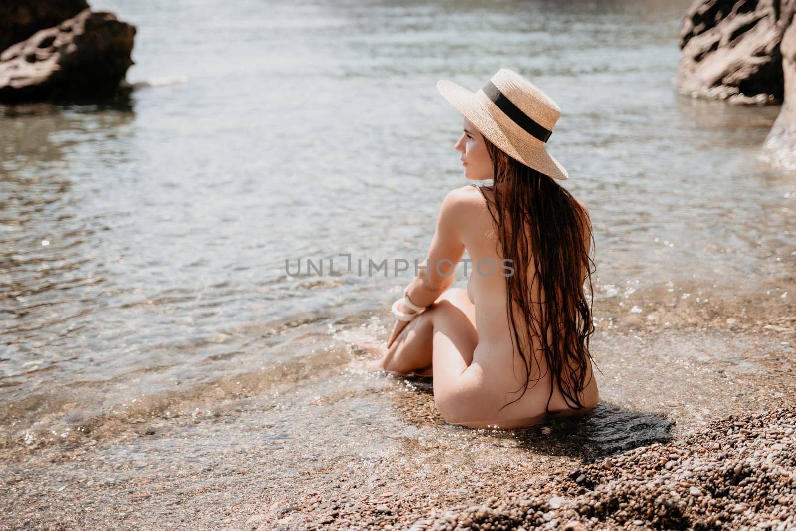 Woman travel sea. Happy tourist in hat enjoy taking picture outdoors for memories. Woman traveler posing on the beach at sea surrounded by volcanic mountains, sharing travel adventure journey by panophotograph