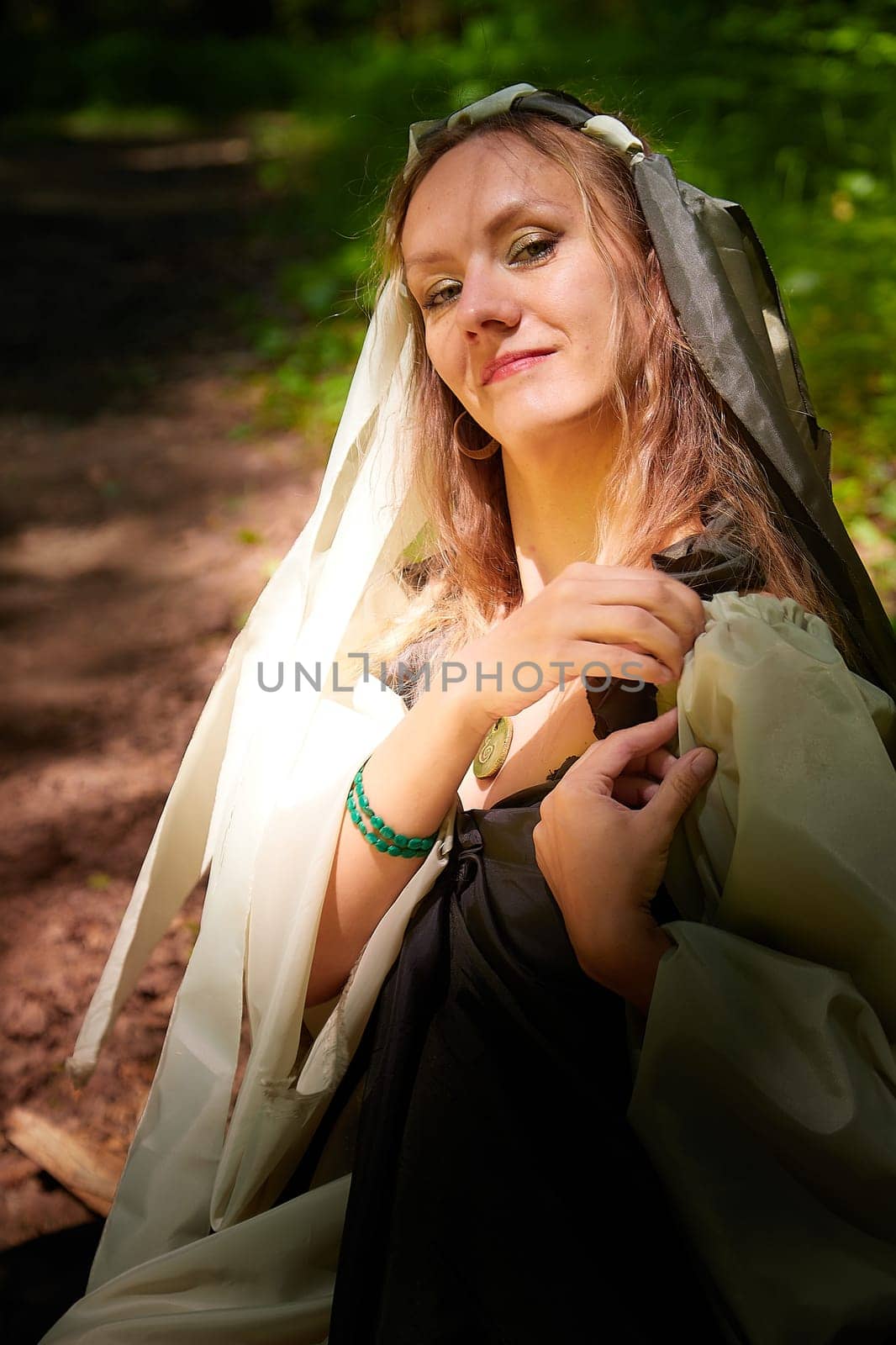 Beautiful seductive dryad. Pagan spirit of forest. Portrait of beautiful dryad. Fairy who loves nature in beautiful green summer forest. Concept of environmental friendliness and caring for nature