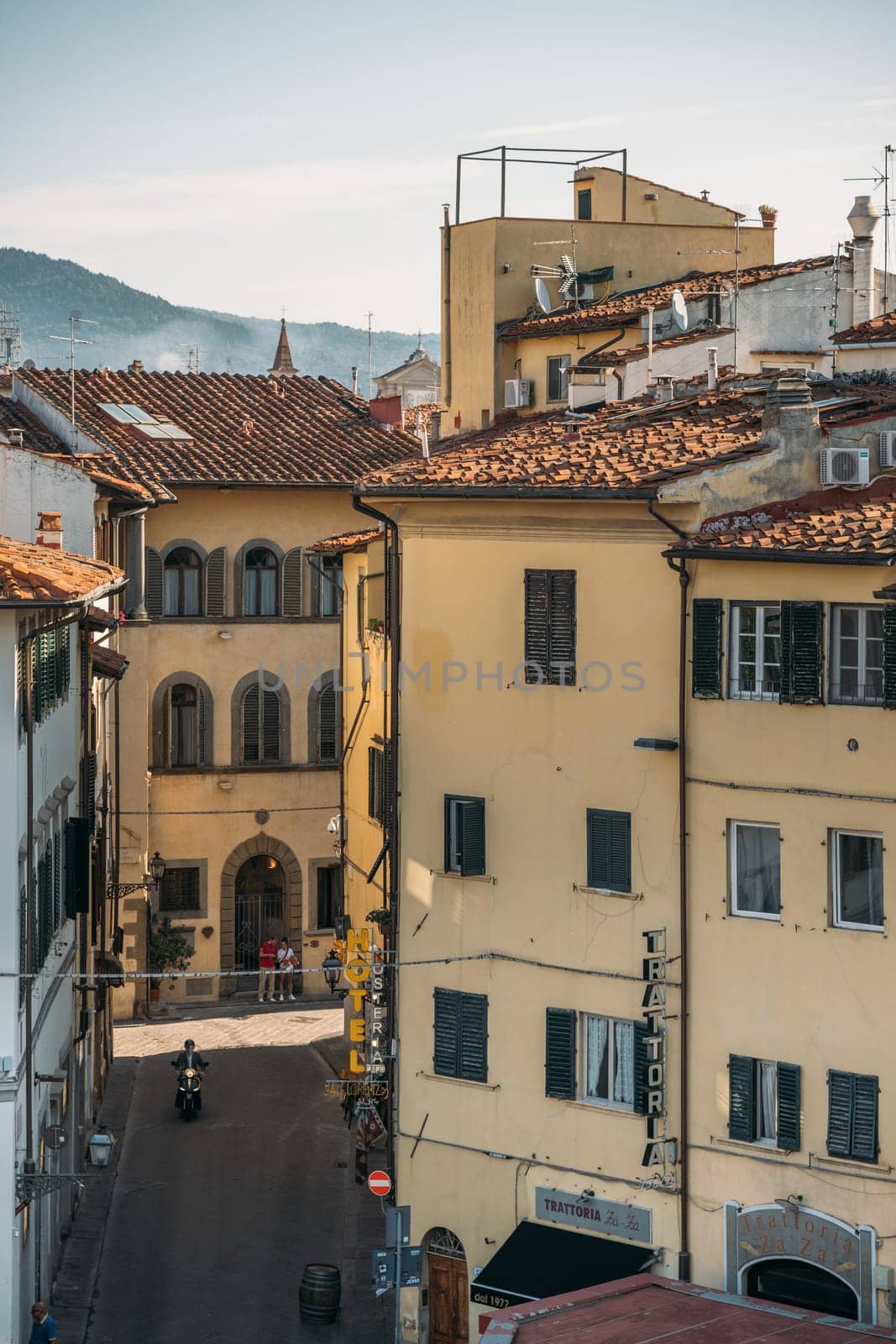 29 SEPTEMBER 2021, FLORENCIA, ITALY: Top view of a beautiful orange colored old tenement house with arches in Florence on a sunny warm summer day. Concept of beautiful old european architecture by apavlin