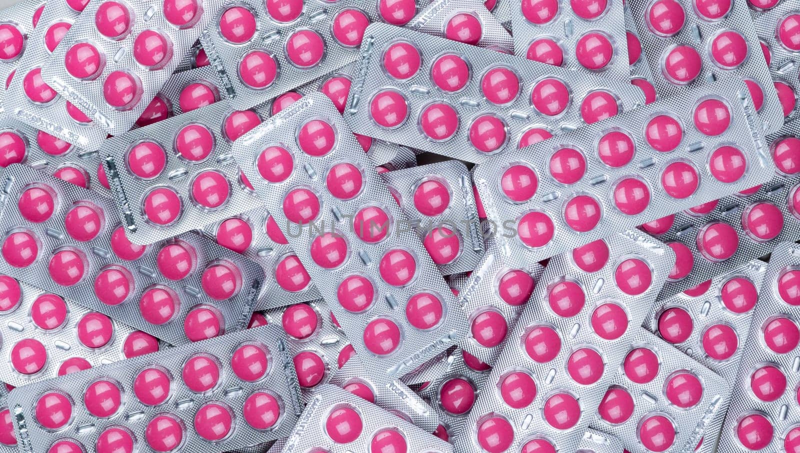 Full frame heap of round pink tablets pills in blister pack. Prescription drugs. Painkiller medicine. Pharmaceutical industry. Ibuprofen for pain treatment. Healthcare and medicine background. by Fahroni