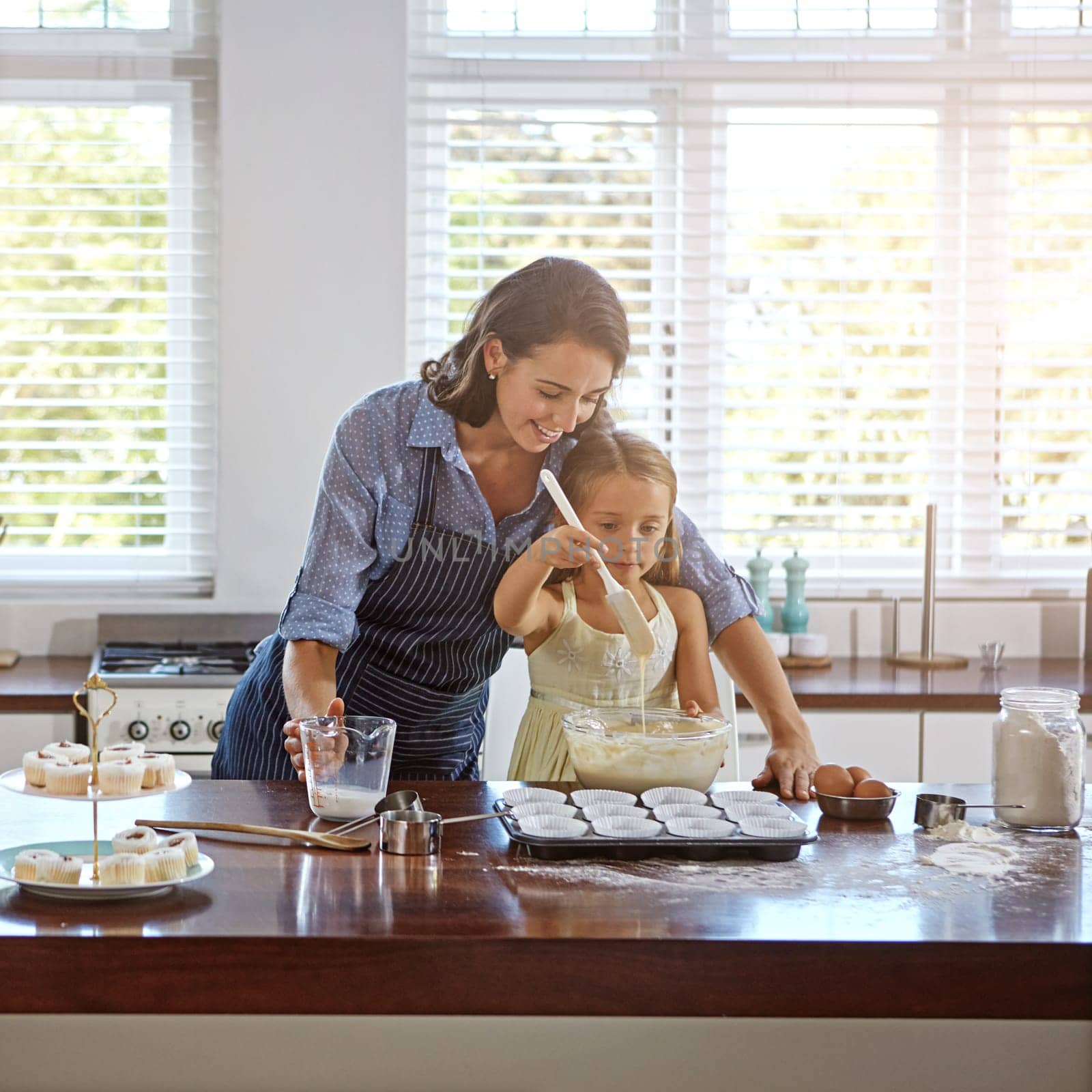 Learning how to bake with mom. a mother and her daughter baking in the kitchen