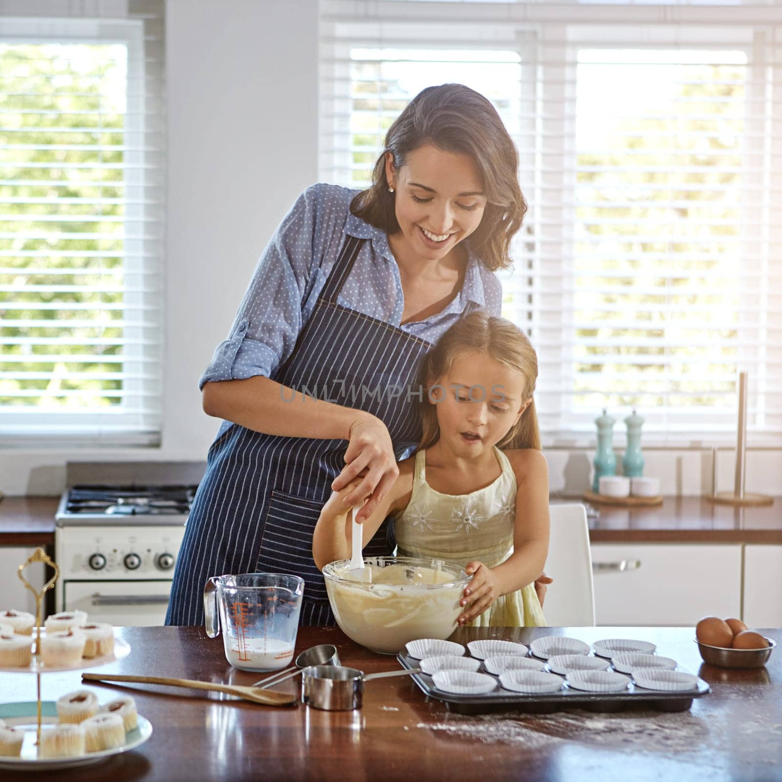 Thats what I call perfect batter. a mother and her daughter baking in the kitchen. by YuriArcurs