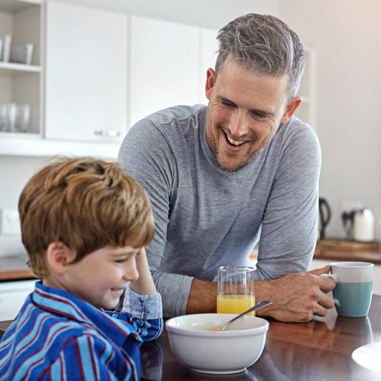 Dad makes the best breakfast. a mid adult man and his son at home in the morning. by YuriArcurs