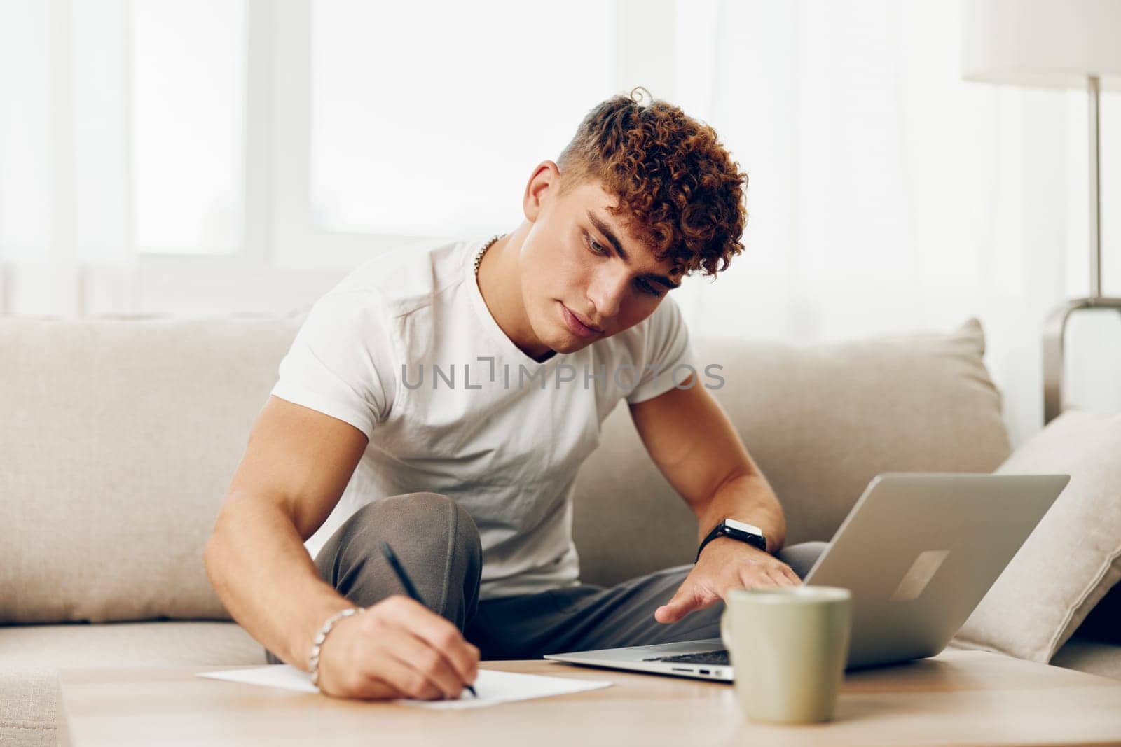 man interior student job laptop white room happy caucasian sofa typing browsing indoor person by SHOTPRIME