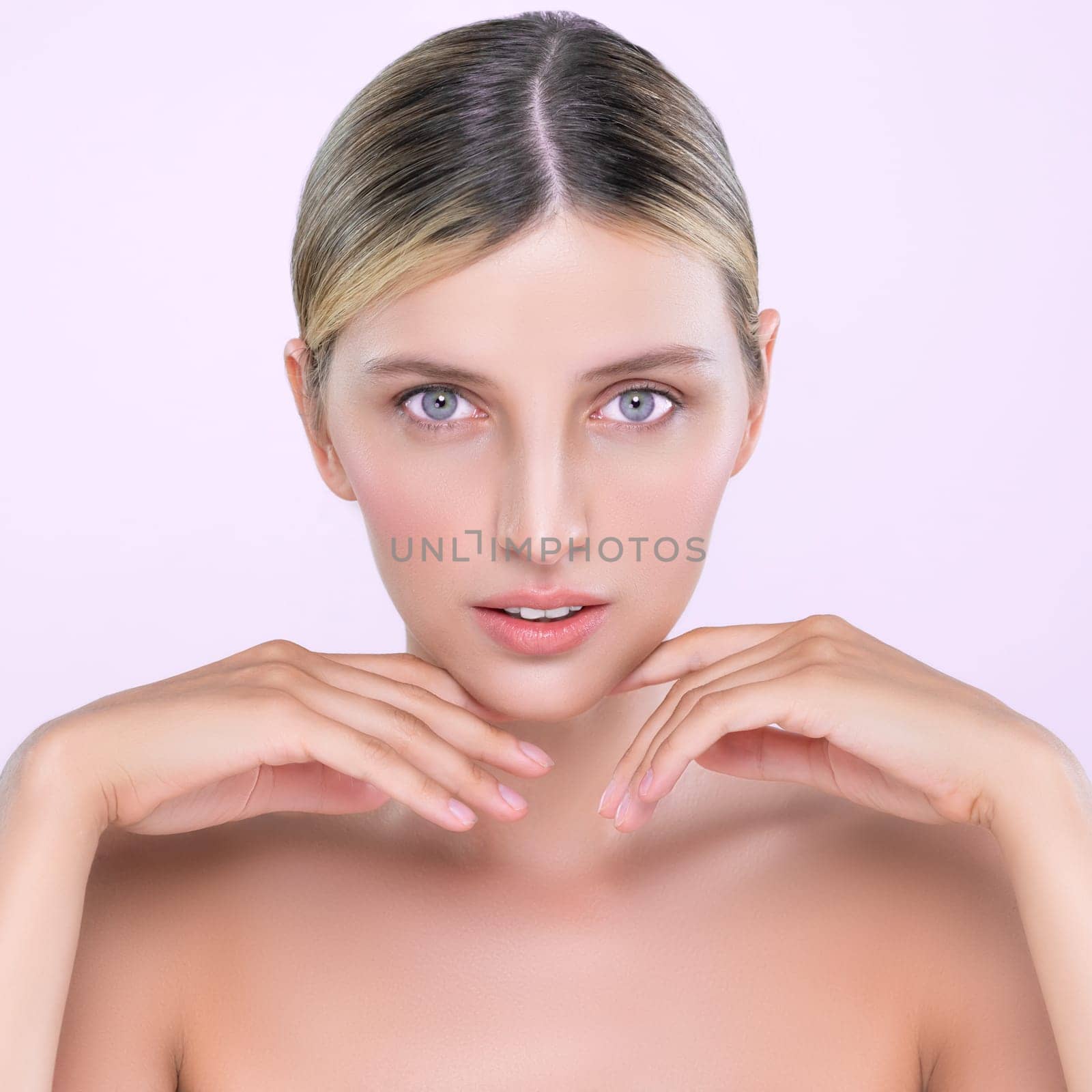 Alluring beautiful woman with perfect smooth and clean skin portrait in isolated background. Beauty hand gesture with expressive facial expression for skincare treatment product or spa.