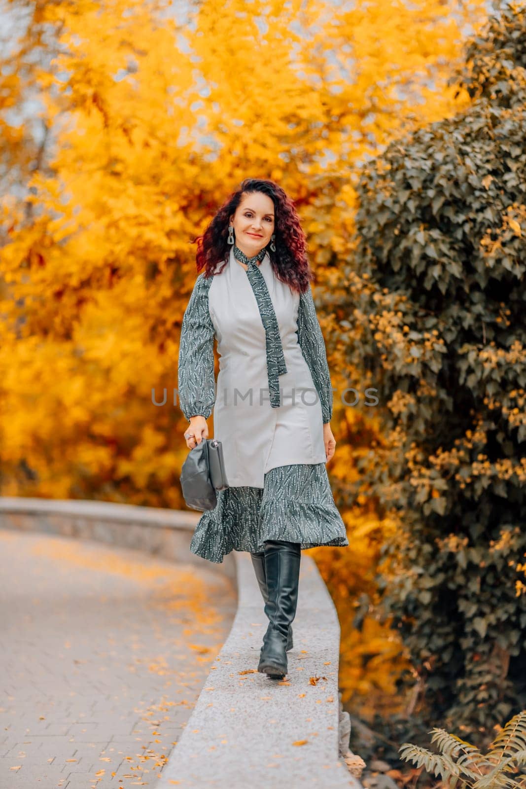 A woman walks outdoors in autumn, enjoys the autumn weather