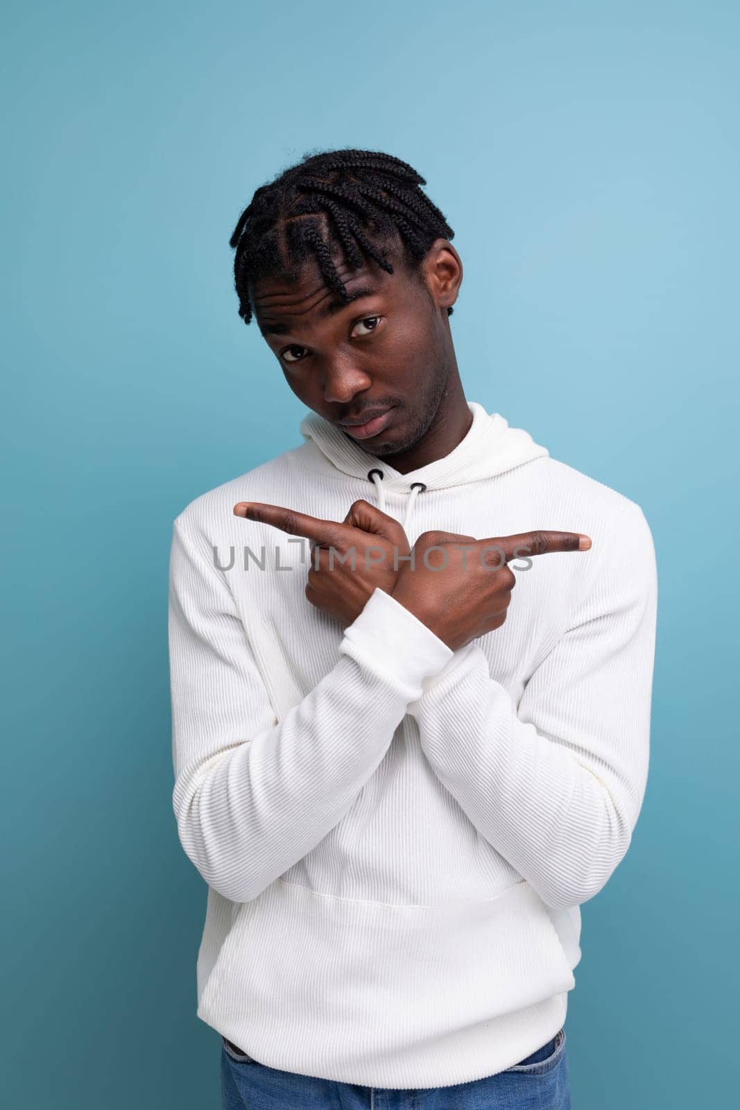 confident proud american man with dreadlocks shows with hands for having an idea on studio isolated background.