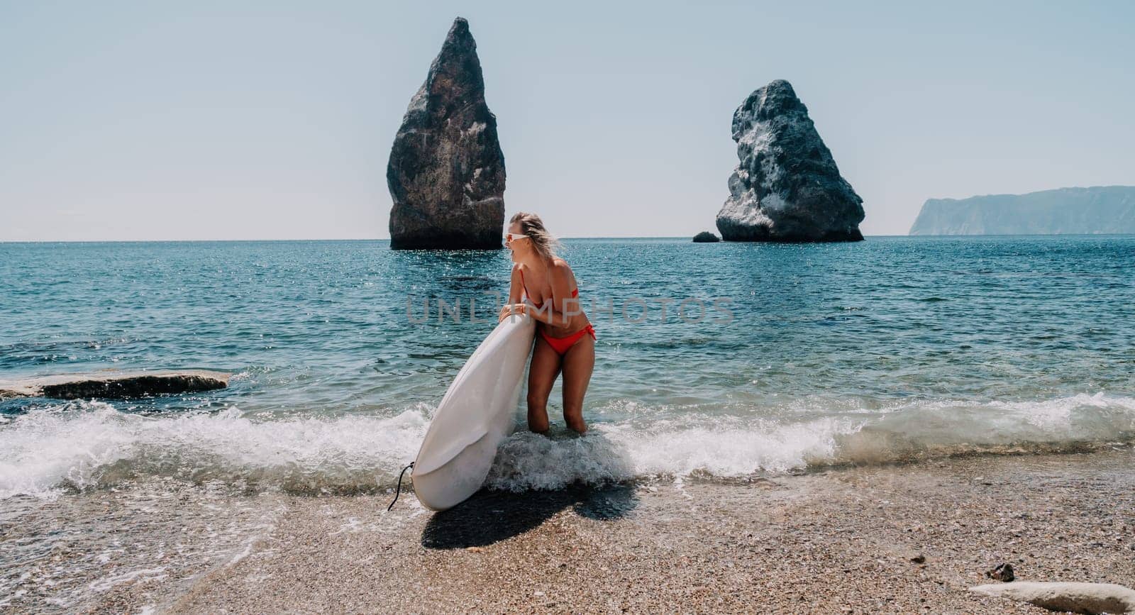 Woman sea sup. Close up portrait of happy young caucasian woman with blond hair looking at camera and smiling. Cute woman portrait in red bikini posing on sup board in the sea by panophotograph