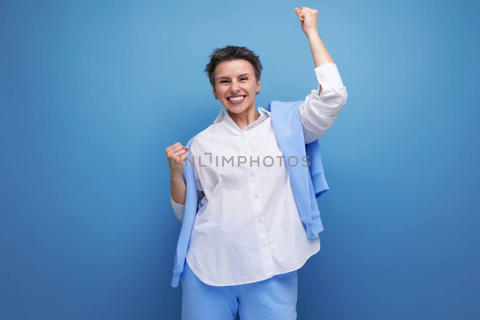 cheerful bright cheerful young dark-haired woman with a short haircut in a white shirt.