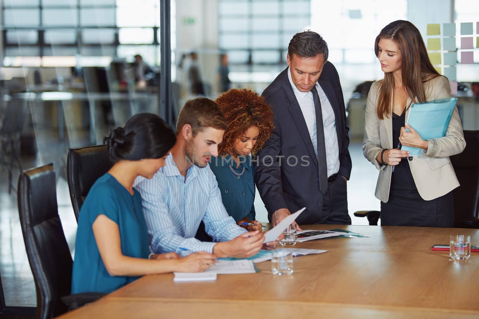 The hours that ordinary people waste, extraordinary people leverage. a group of businesspeople having a meeting in the boardroom. by YuriArcurs