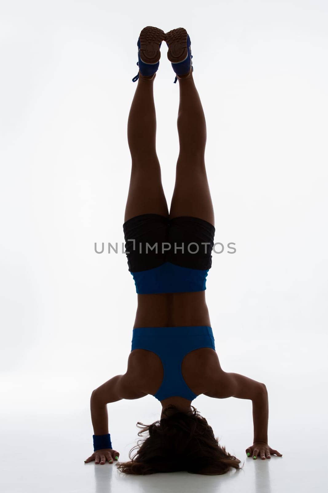 Sport and active lifestyle. Sporty flexible girl fitness woman in sportswear doing stretching exercise on light background. silhouette