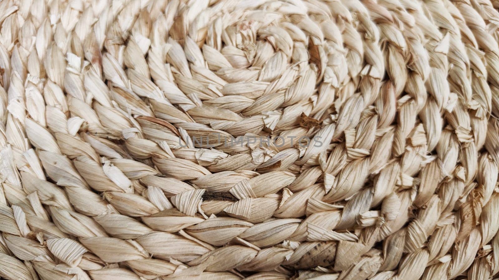 Round braided natural straw table mat texture as a background. Full frame of tightly woven straw pattern. Ppace, copy space for text, for a background