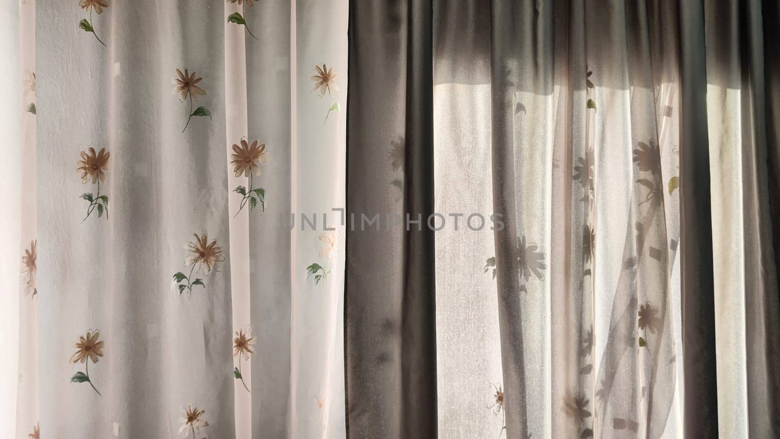Transparent tulle curtains with floral pattern on the window and light behind the glass. Abstract Background, texture and copy space