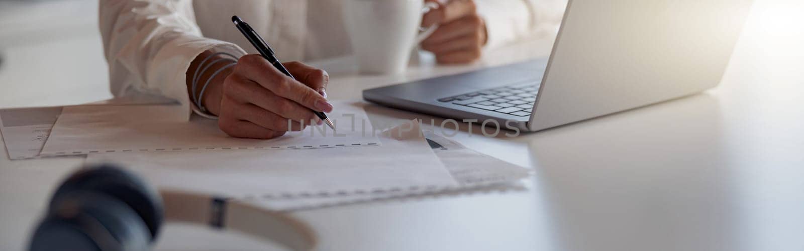 Close up of business woman working laptop and making notes sitting in office. Blurred background