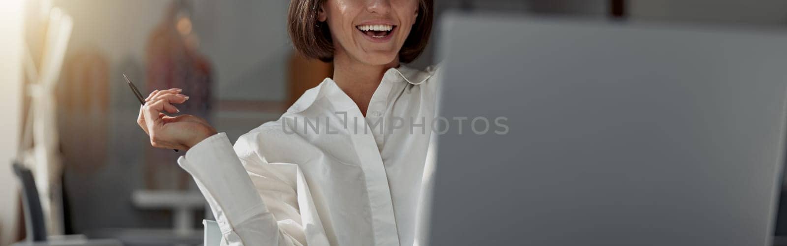 Smiling business woman working laptop while sitting in modern office. Blurred background