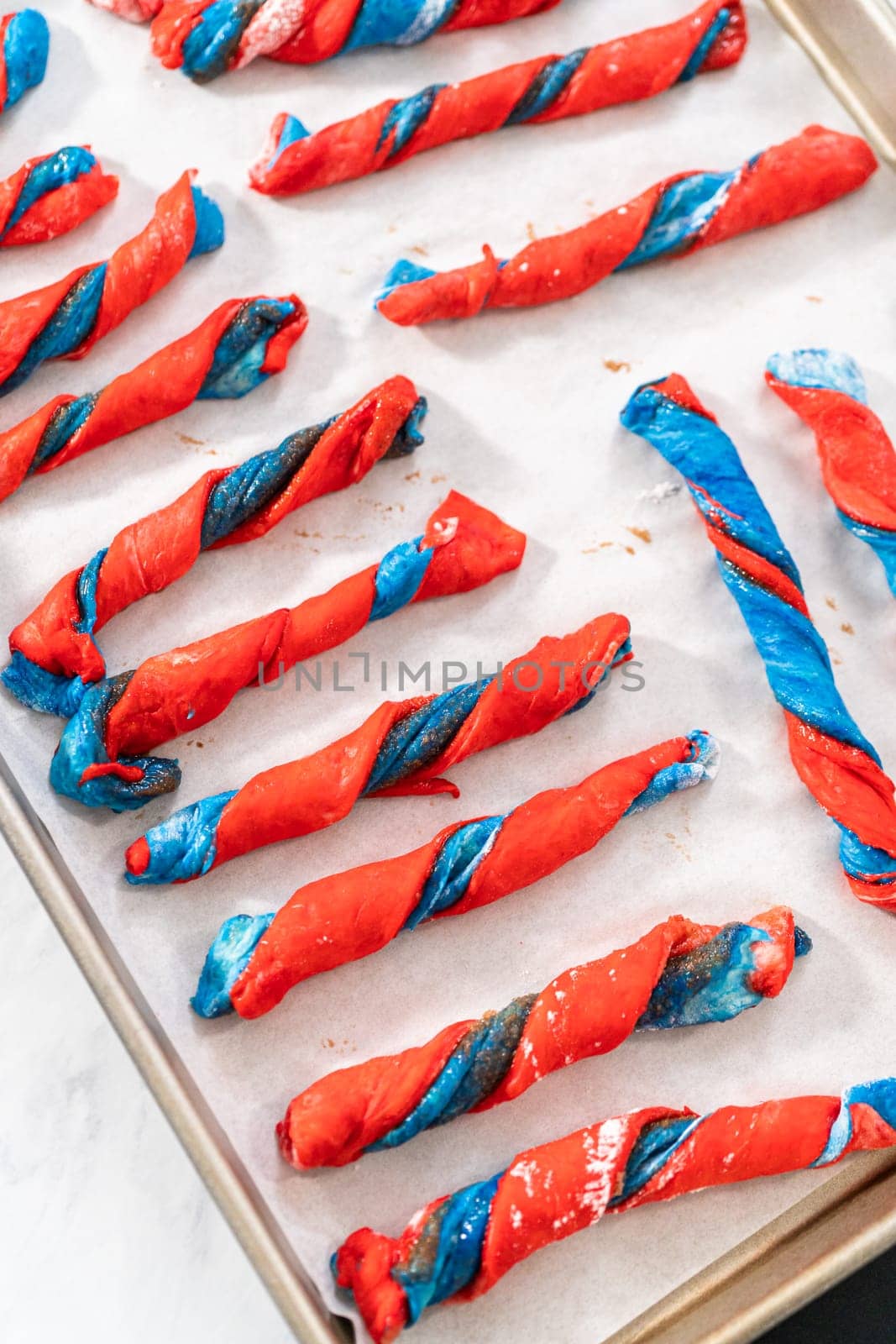 Rising patriotic cinnamon twists on the baking sheet lined with parchment paper.