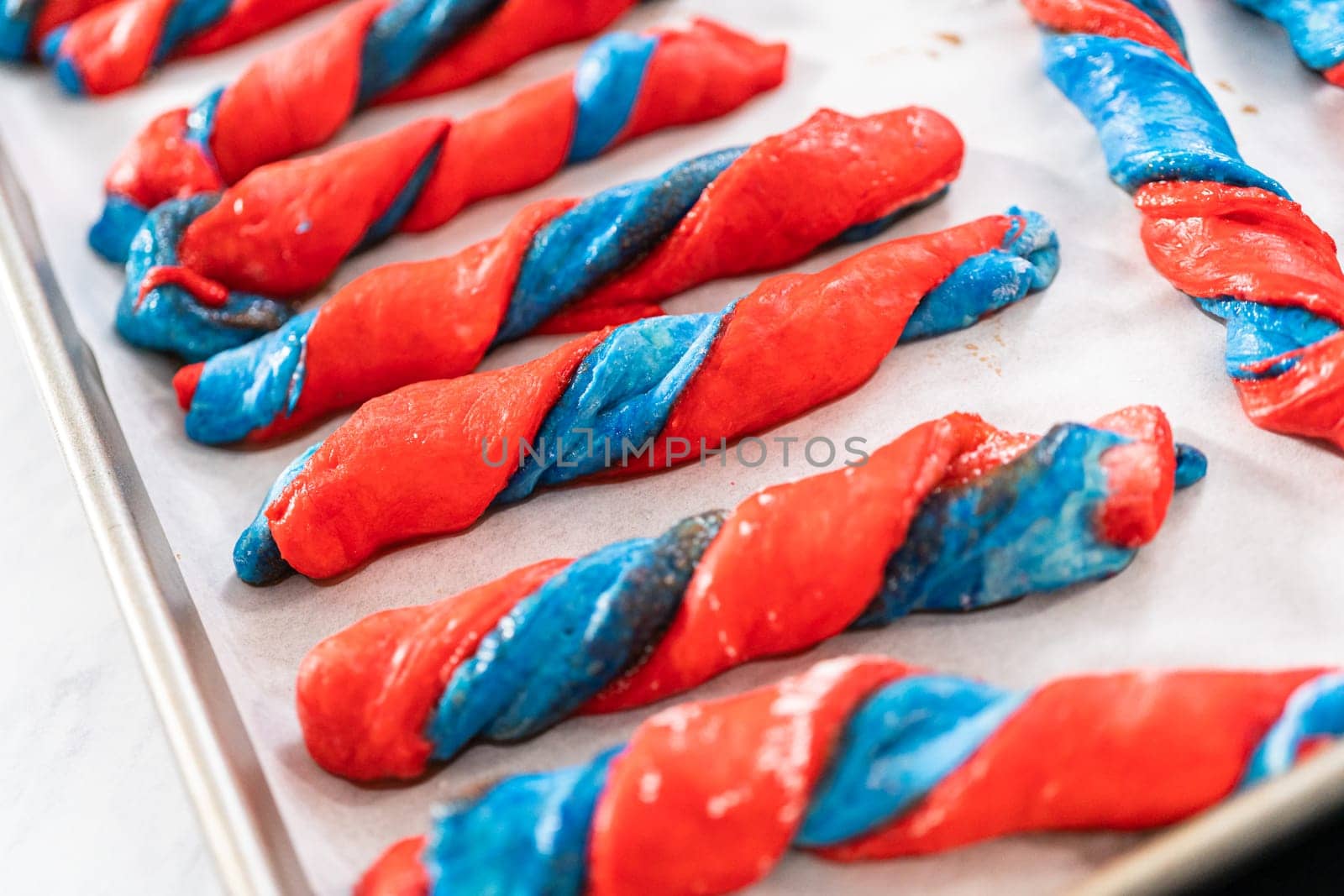 Rising patriotic cinnamon twists on the baking sheet lined with parchment paper.