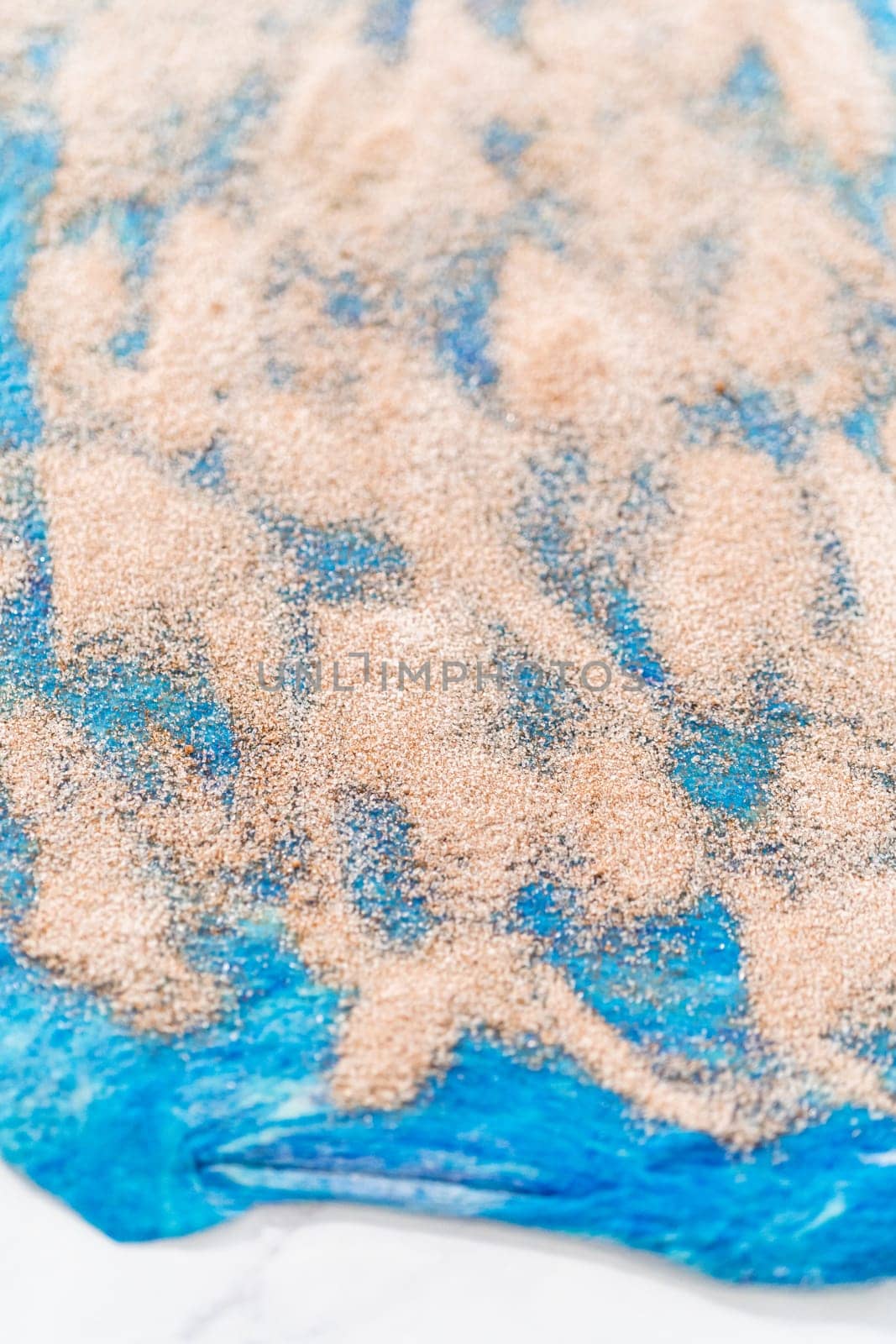 Rolling red and blue bread dough to bake patriotic cinnamon twists.