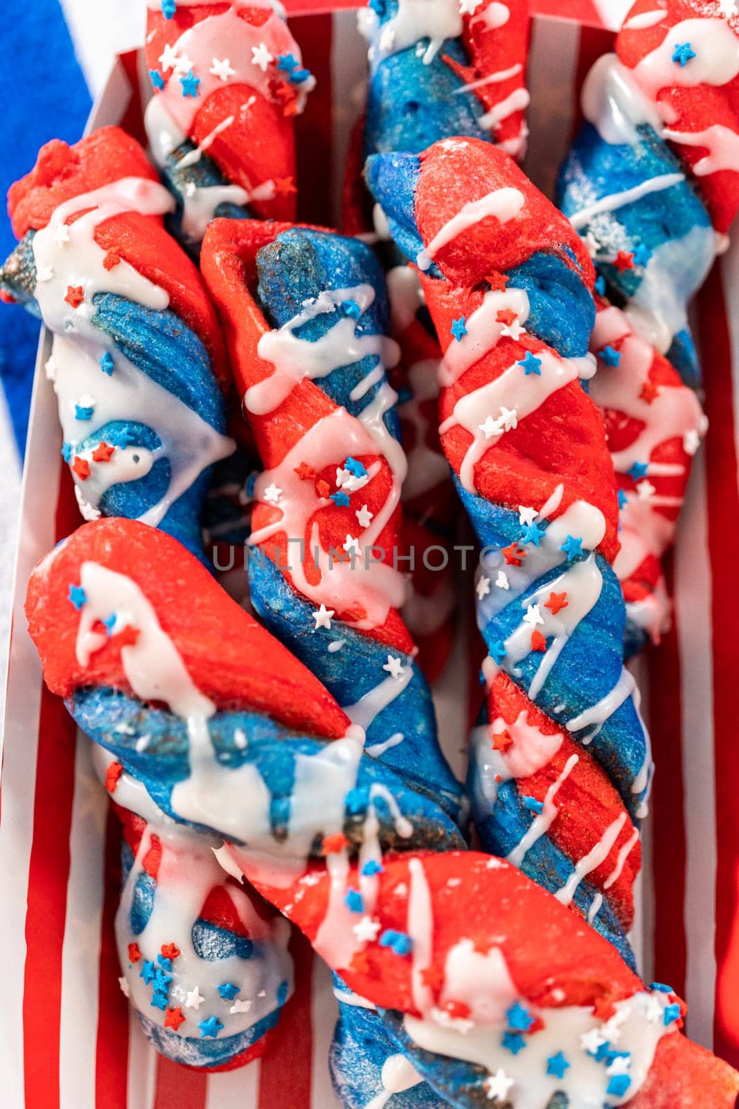 Patriotic cinnamon twists drizzled with a white glaze and decorated with star sprinkles.