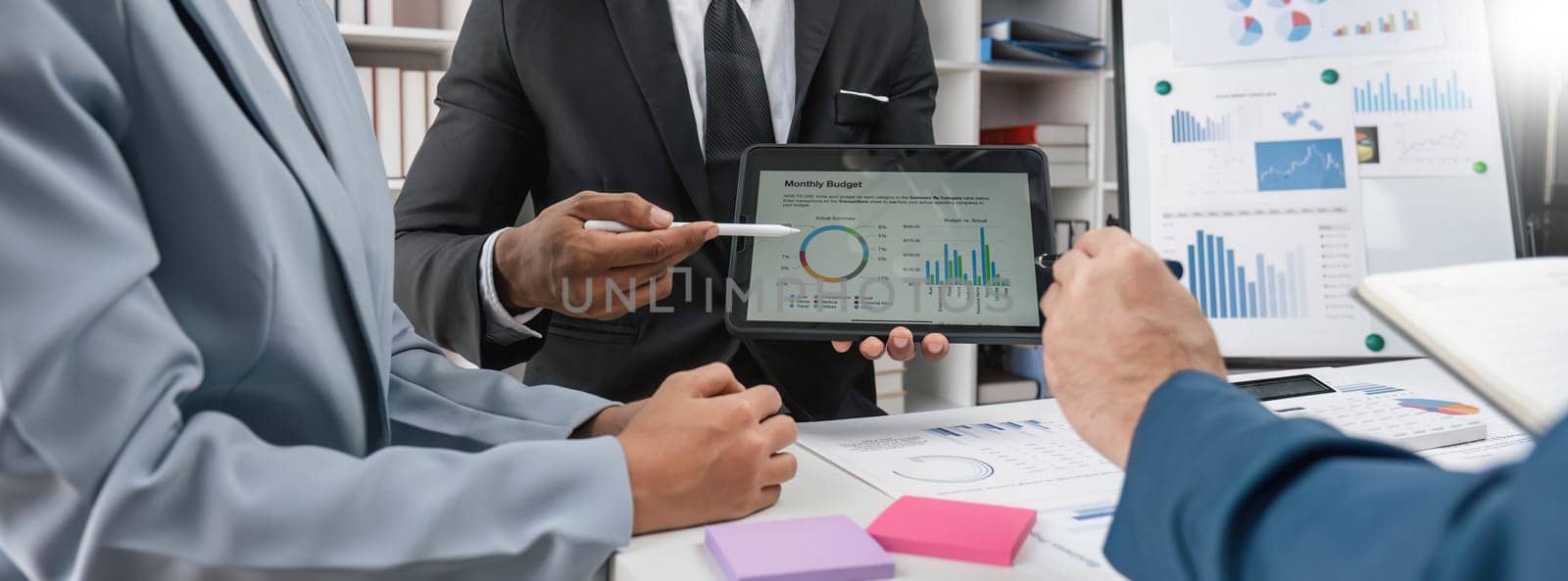 Business People Meeting using laptop computer,calculator,notebook,stock market chart paper for analysis Plans to improve quality next month. Conference Discussion Corporate Concept. by wichayada