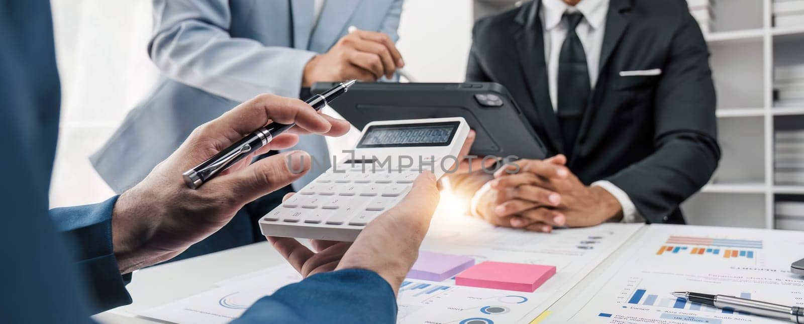 Business People Meeting using laptop computer,calculator,notebook,stock market chart paper for analysis Plans to improve quality next month. Conference Discussion Corporate Concept. by wichayada