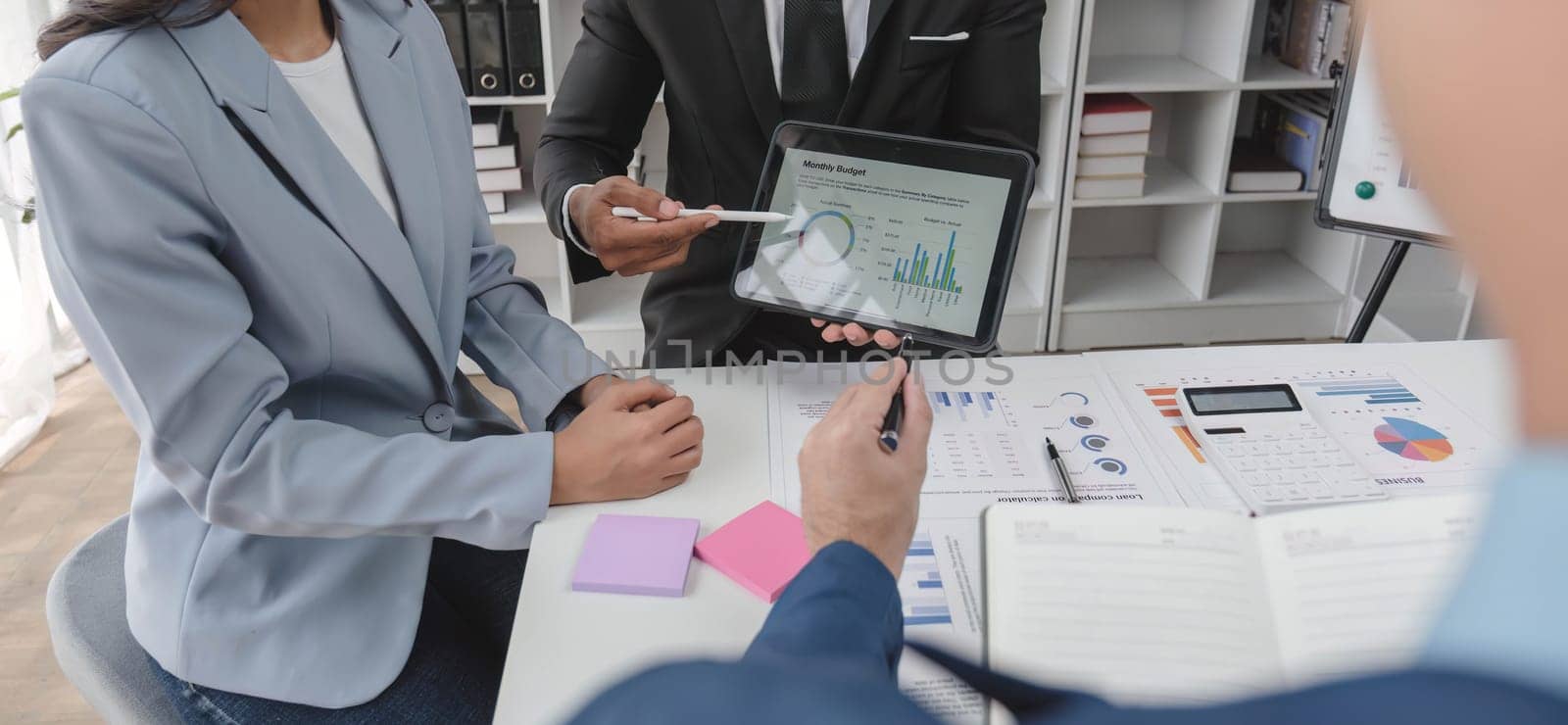 Business People Meeting using laptop computer,calculator,notebook,stock market chart paper for analysis Plans to improve quality next month. Conference Discussion Corporate Concept...