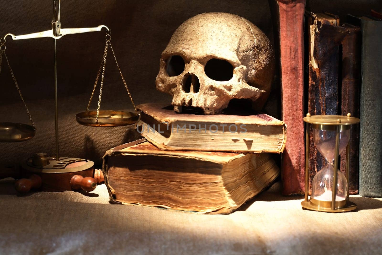 Nice vintage still life with human skull near balance and books