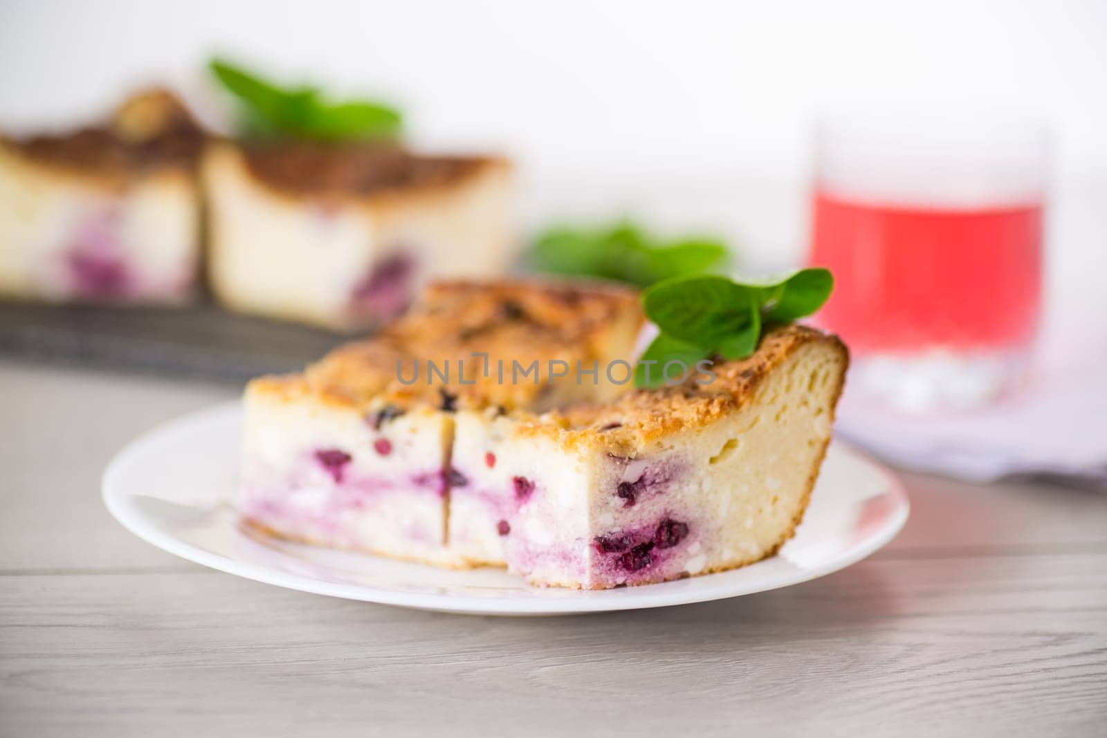 cooked cottage cheese casserole with berry filling in a plate on the table