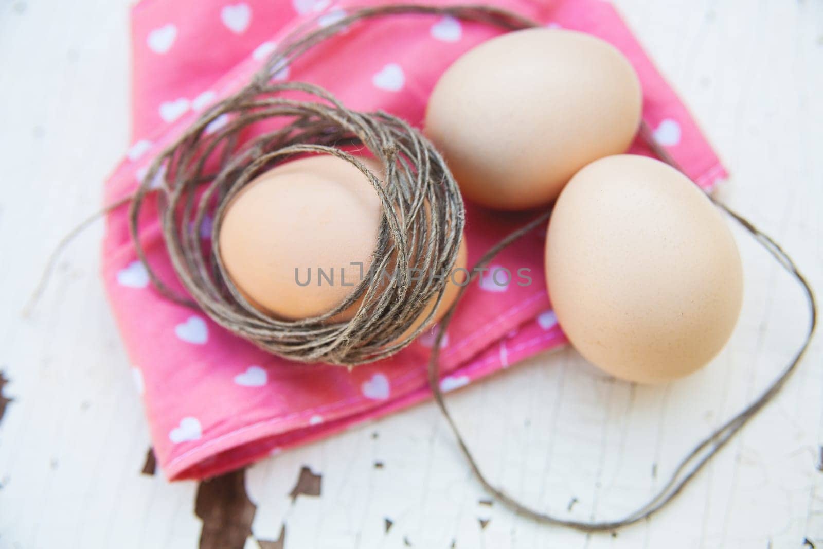 Top view of three eggs on rose napkin close up by sfinks