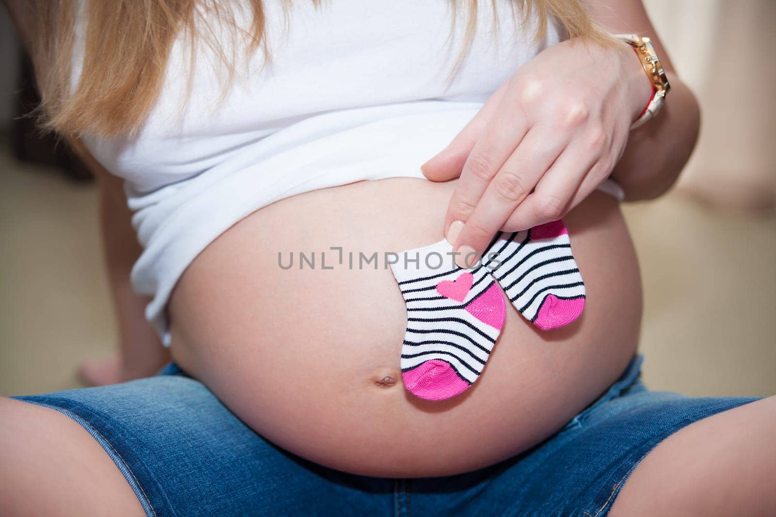 Small shoes for the unborn baby in the belly by sfinks