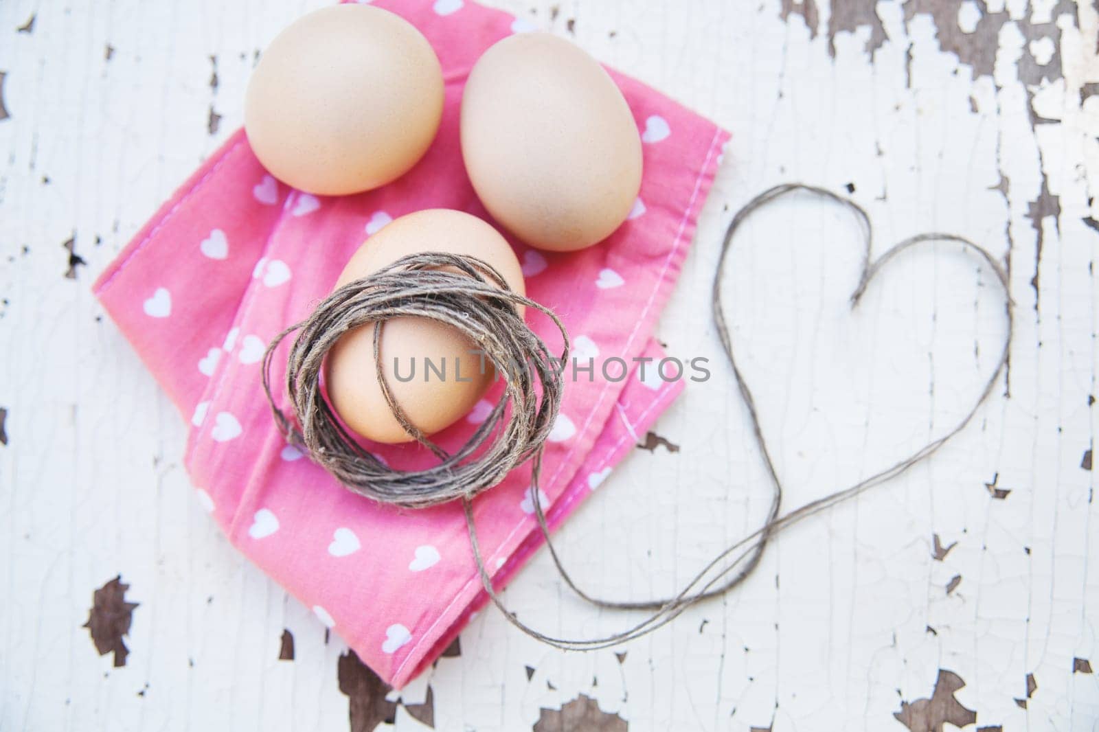 Top view of three eggs on rose napkin.