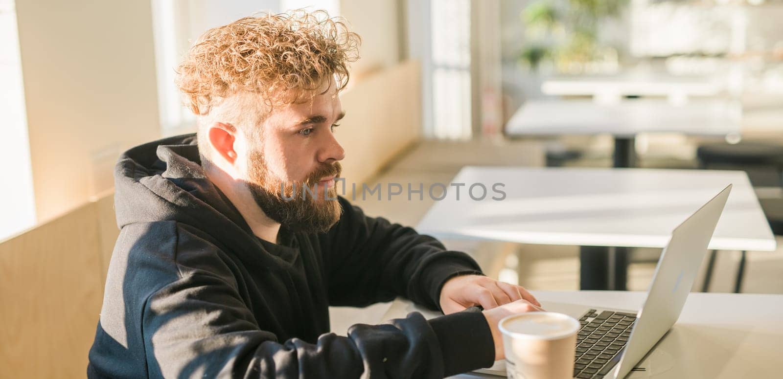 Close-up banner male guy portrait resting in coffee shop chatting in social networks skilled freelancer enjoying remote job typing publication for web blog on laptop copy space by Satura86
