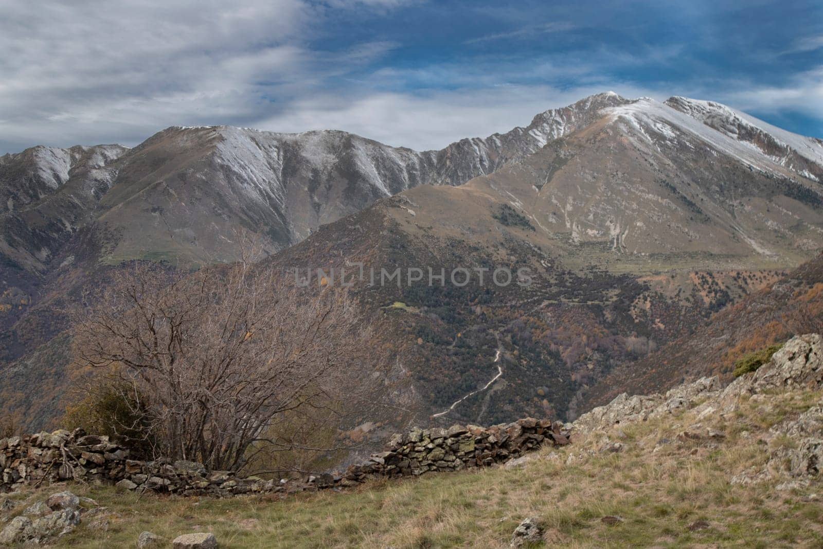 Snowy mountains under cloudy sky landscape in Boi Valley in Pyrenees in Catalonia