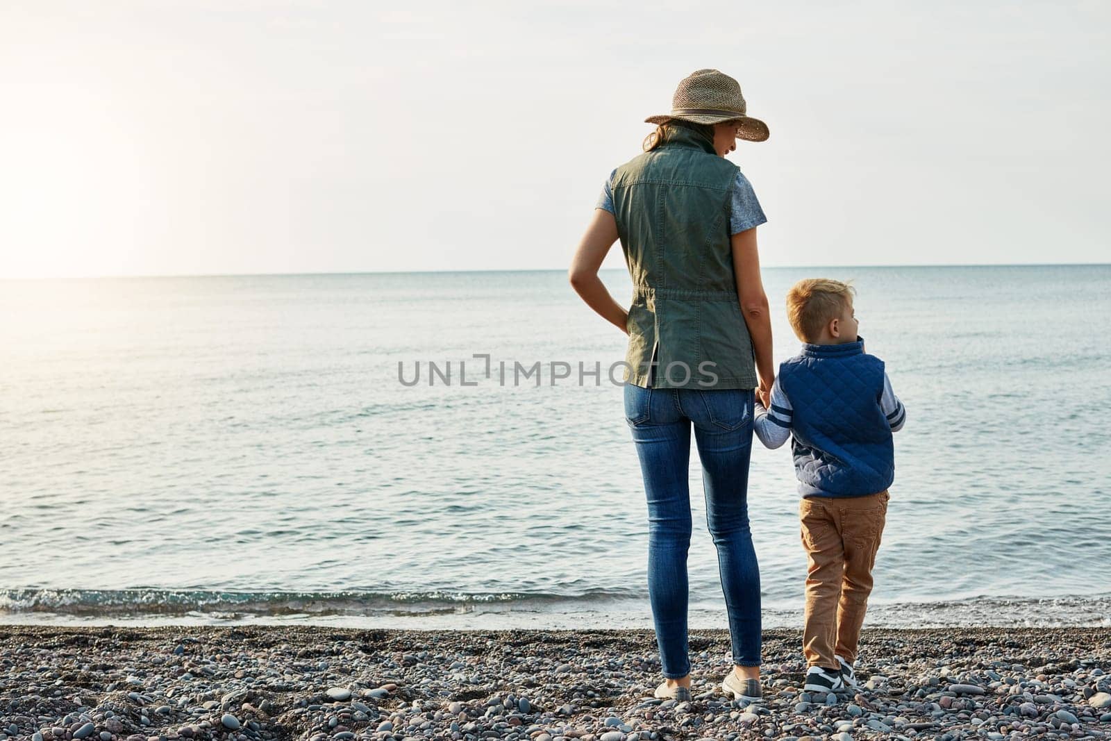 Admiring the beauty of nature. a young woman and her son enjoying a walk by the water