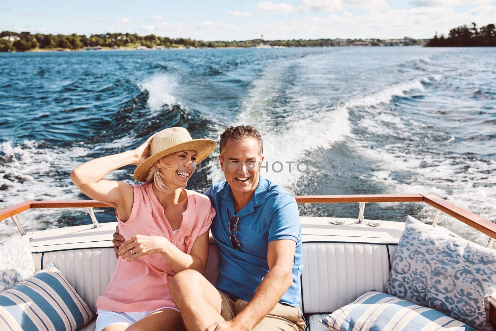 Its not where you go, its who you travel with. a mature couple enjoying a relaxing boat ride. by YuriArcurs