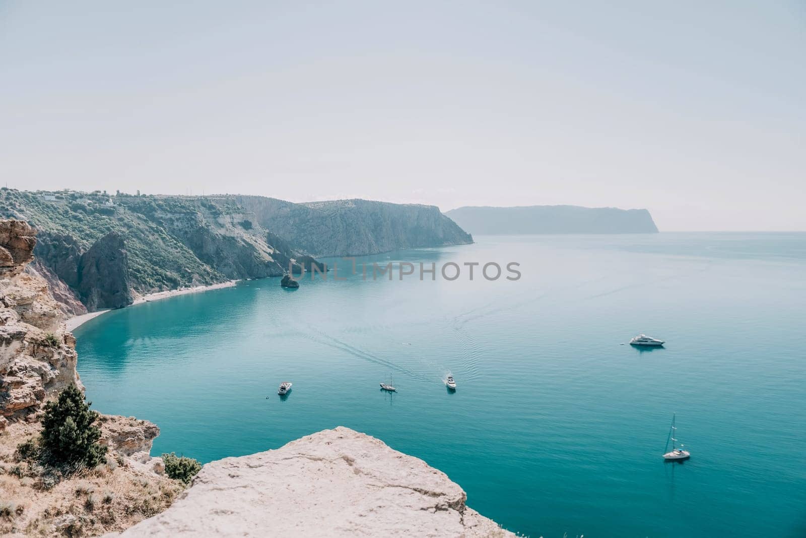 Aerial view from above on calm azure sea and volcanic rocky shores. Small waves on water surface in motion blur. Nature summer ocean sea beach background. Nobody. Holiday, vacation and travel concept by panophotograph