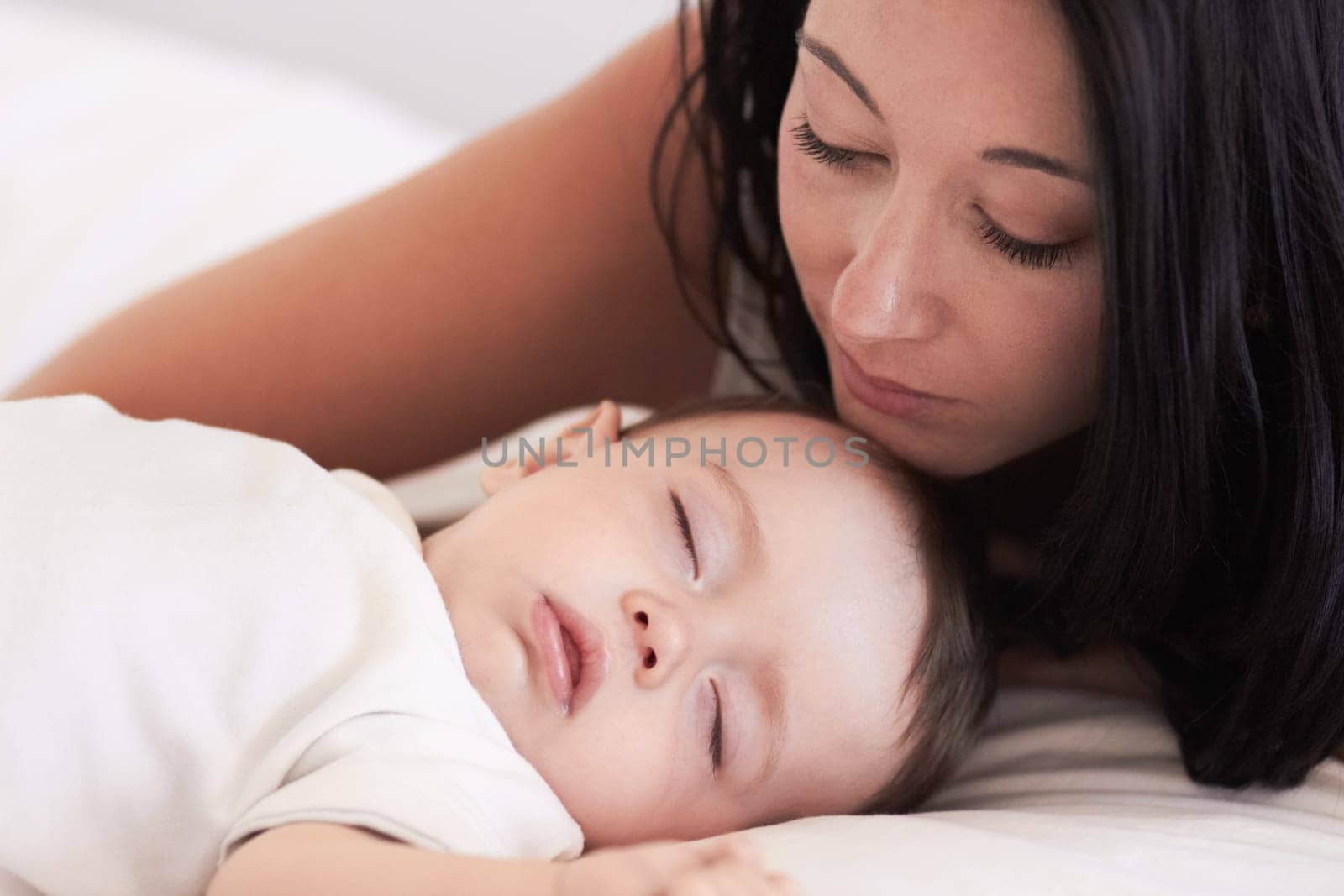 Baby, sleeping and mother in a home bedroom with parent support, care and love. Relax, bed and young girl with mom in a house feeling tired and sleepy with mama rest looking at fatigue of kid.