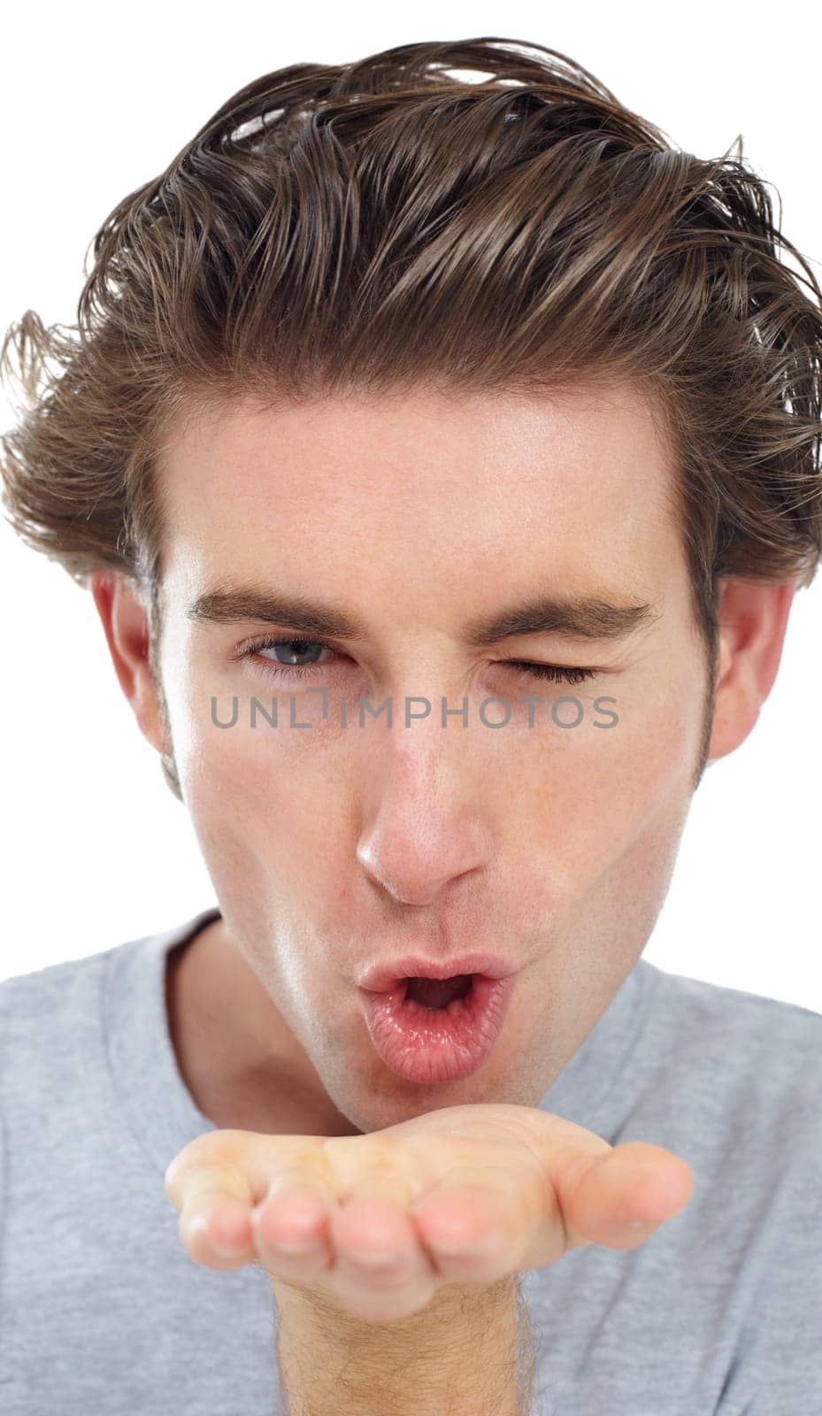 Wink, blowing a kiss and portrait of man in studio for flirting, romance or love. Valentines day, happy and emoji with face of male model and gesture isolated on white background for passion and date.