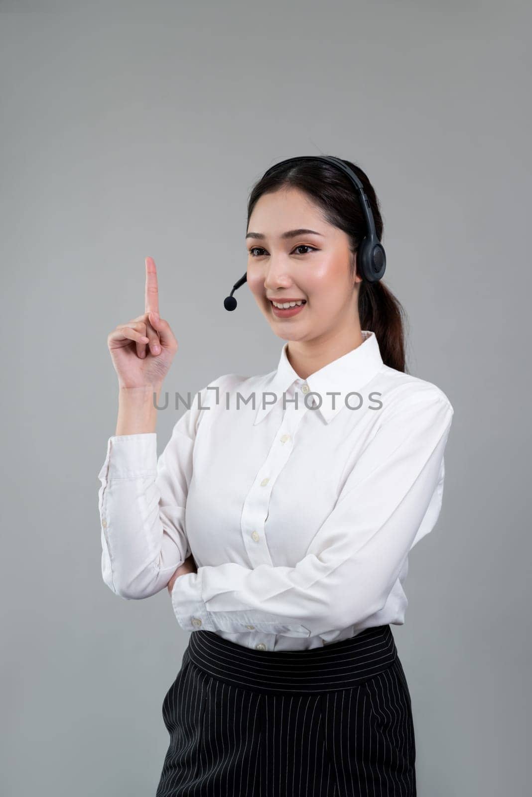 Asian operator wearing formal suit and headset with pointing finger Enthusiastic by biancoblue