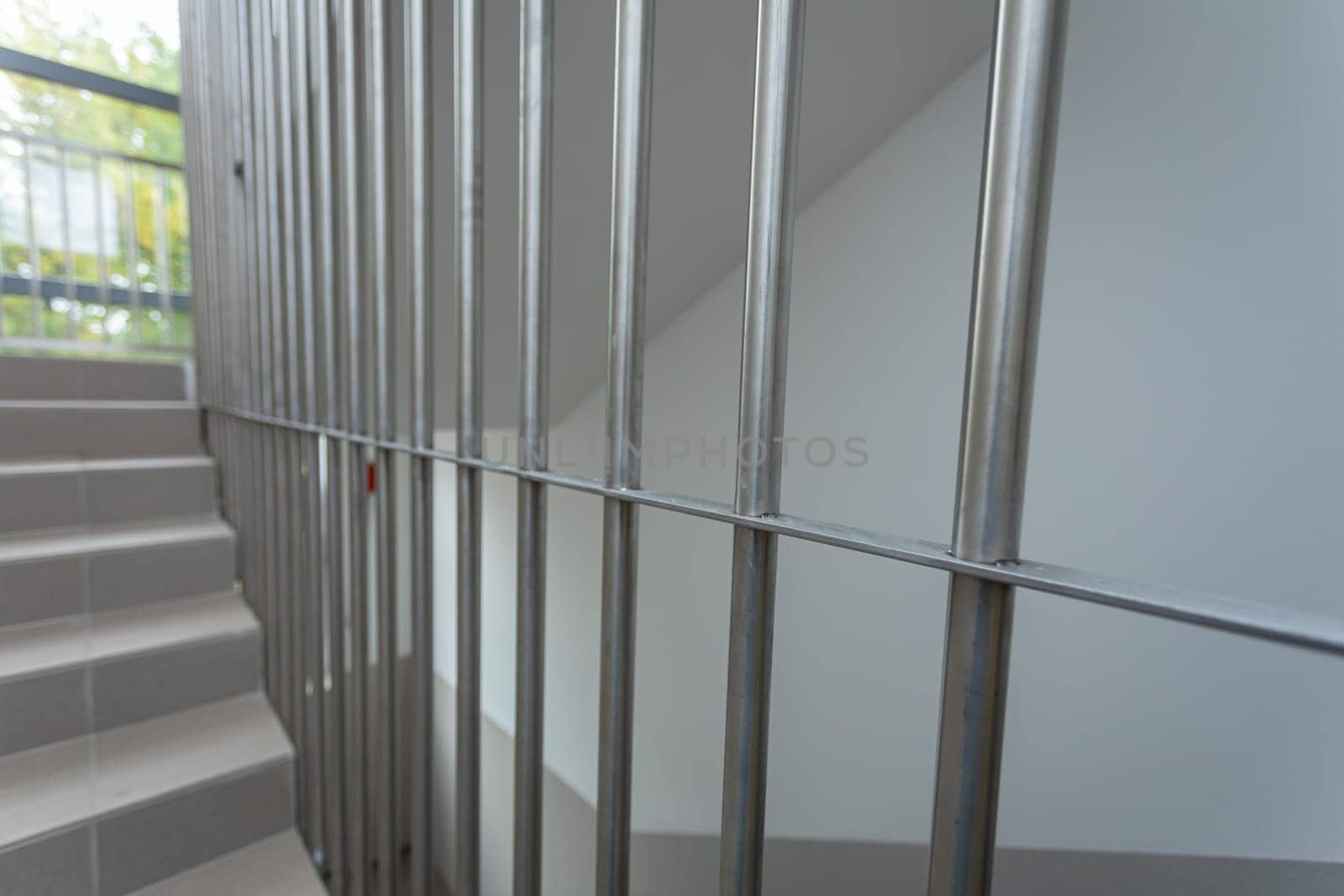 A perspective view of the stainless steel bars mounted on the staircase. Vertically aligned at an equal distance from each other.