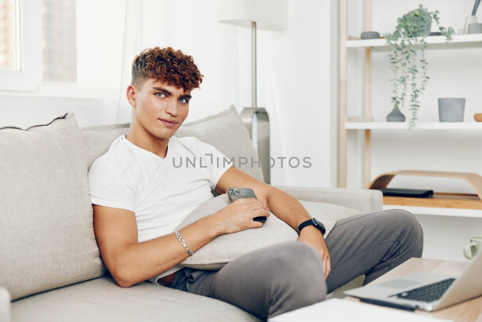 man interior student smile young sofa teenager curly sports business selfies online blissful holding smart technology text