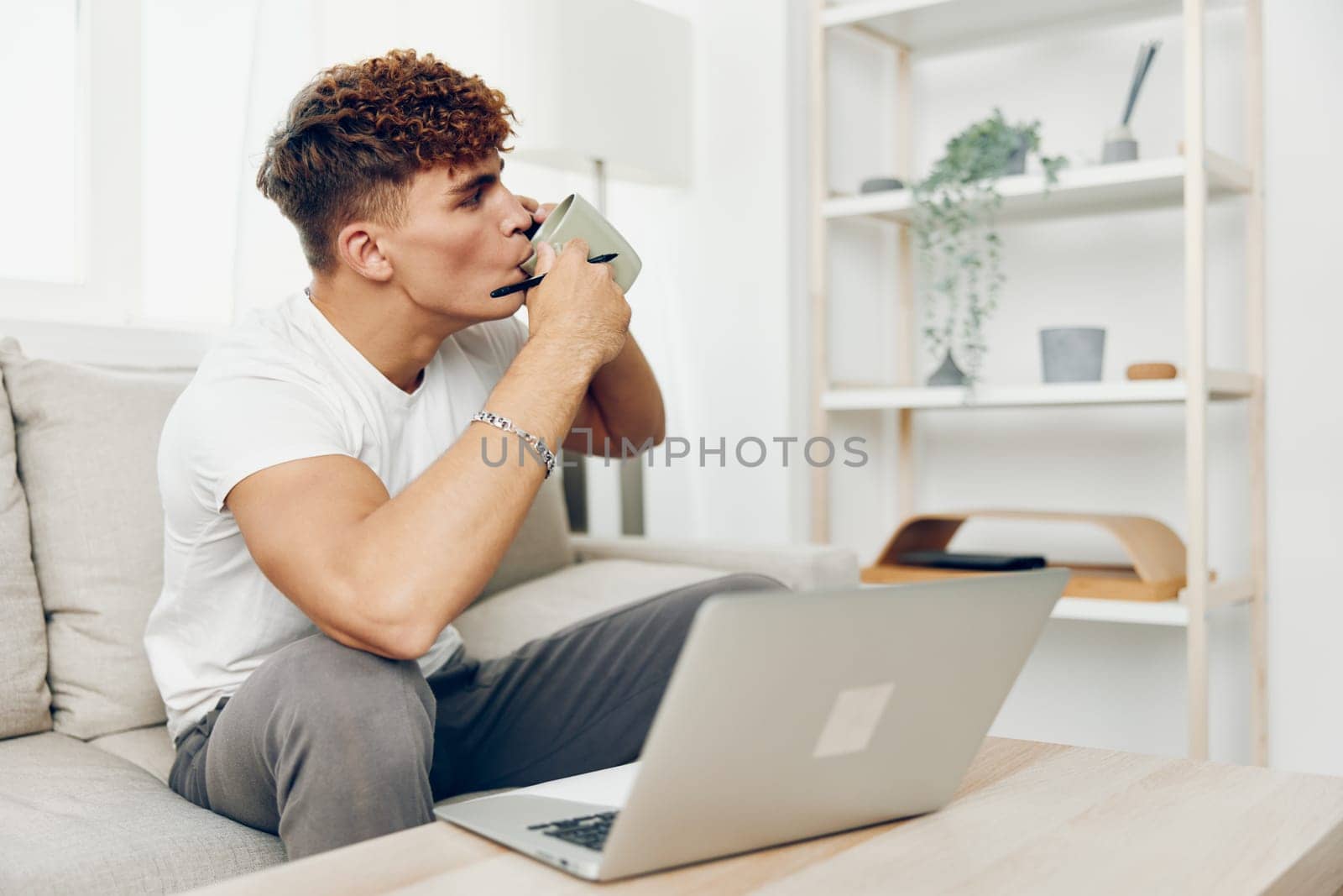 man interior cyberspace using blissful smart modern curly text message sports freelancer male holding home young sitting laptop communication