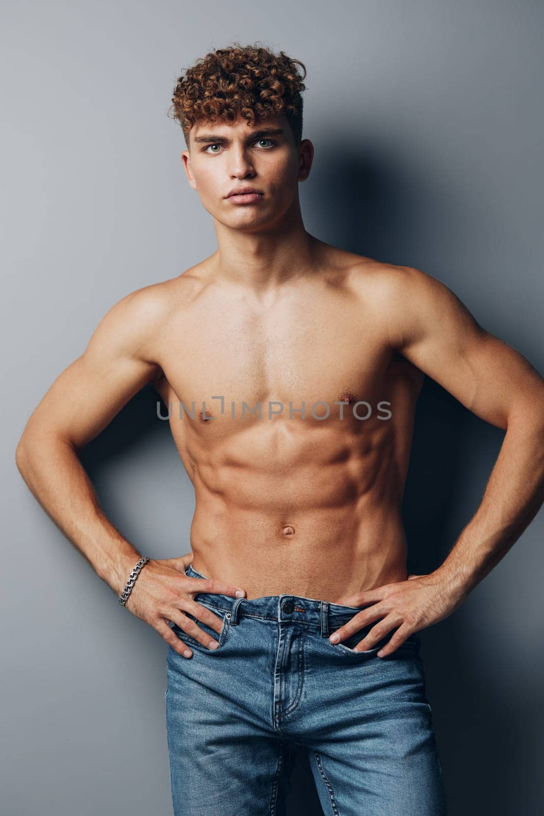 man lifestyle naked strong curly fit fashion bodybuilder standing background bicep abs healthy smile shirtless model gray background torso