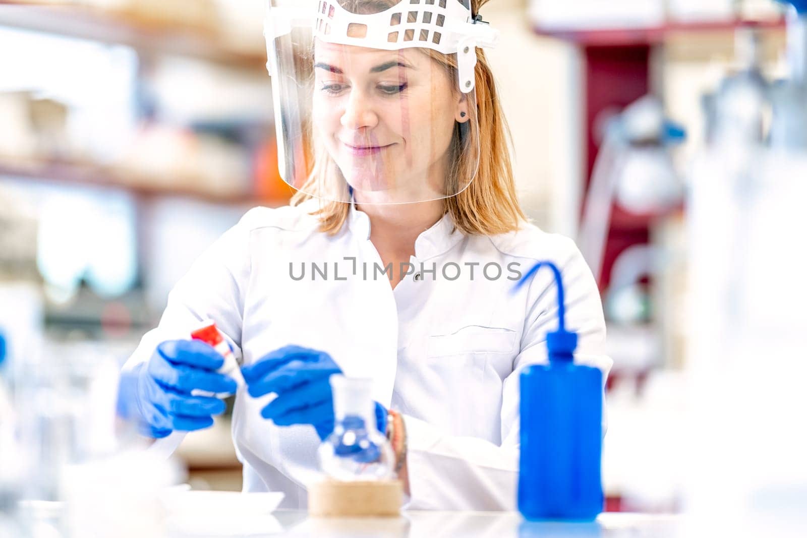 research of dangerous chemical substances in a biochemical laboratory. female scientist uses protective equipment by Edophoto