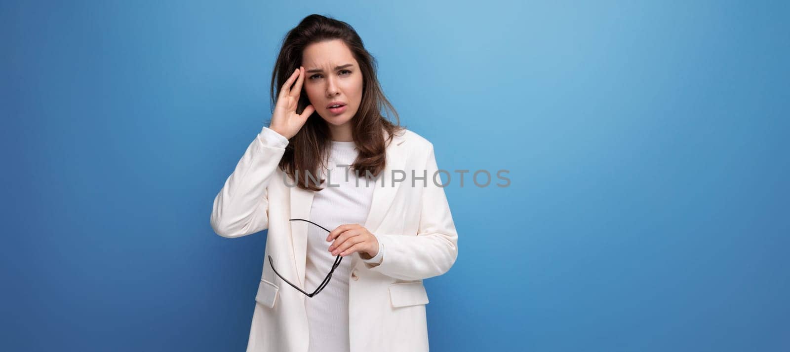 portrait of a young lady in a white dress and glasses with a headache.