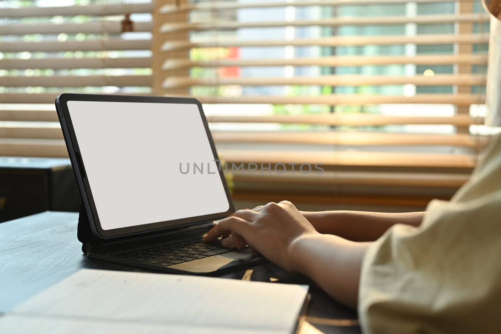 Close up view of woman hands typing on keyboard, studying online classes on digital tablet. Online learning, homeschooling concept.