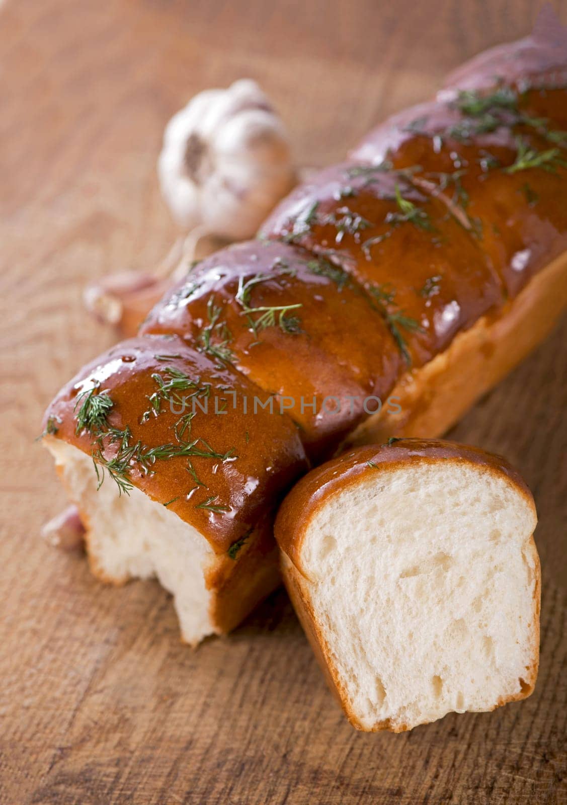 tasty bread with garlic lying on white background
