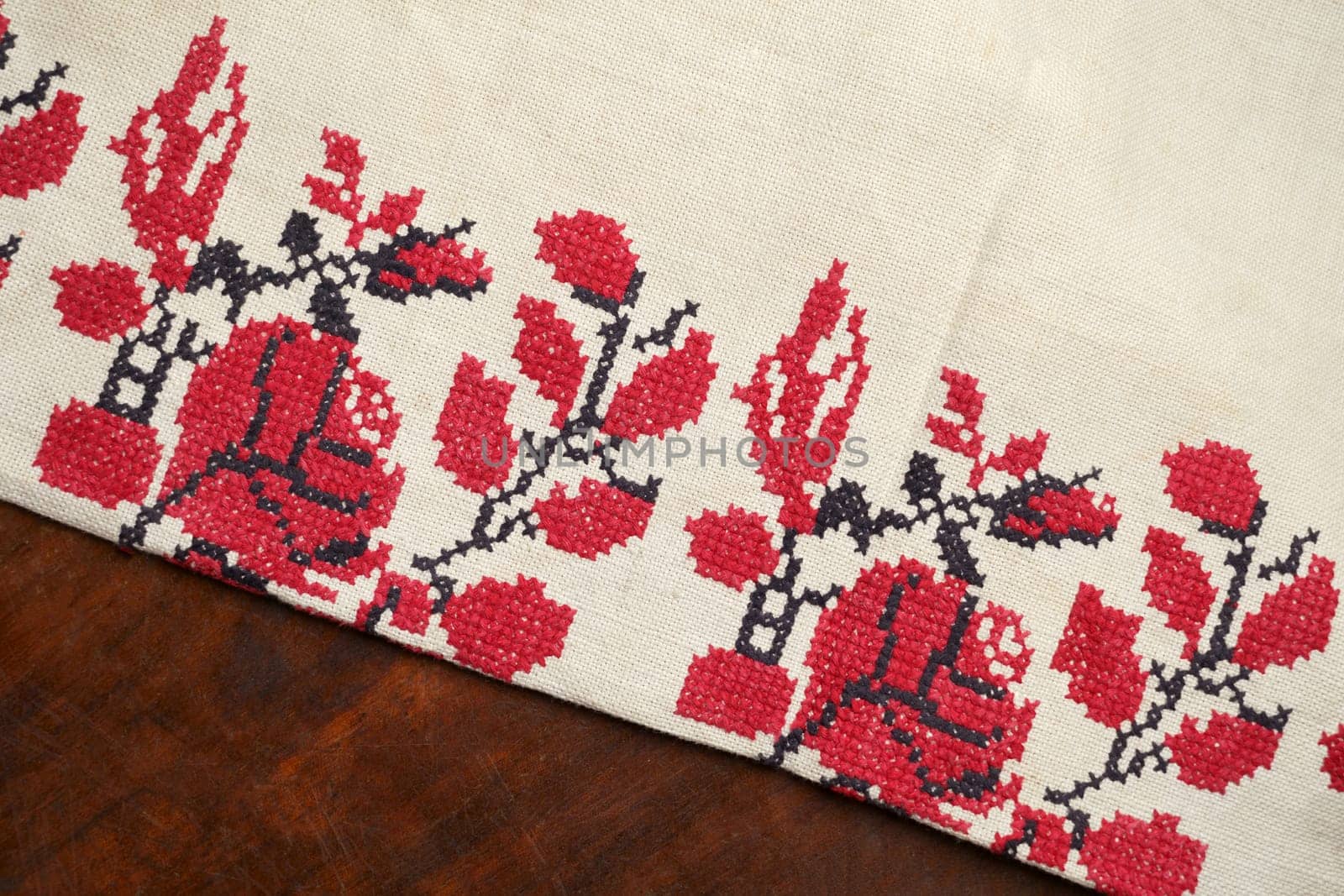 Beige white farmhouse style stripes texture. Woven linen cloth pattern background. Embroidered good like old handmade cross-stitch ethnic Ukraine pattern. Ukrainian rushnyk . Red version over white background. Line striped closeup weave fabric for kitchen towel material. Pinstripe fiber picnic table cloth . Black and red embroidery.